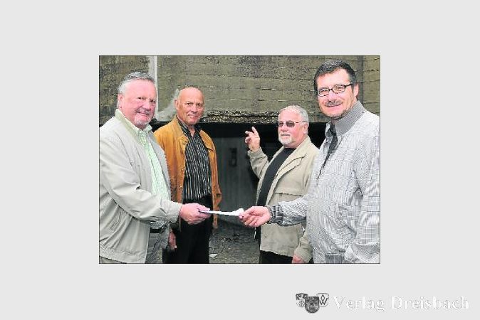 Der Beton bröckelt am Galluszentrum: Reinhard Lehrig zeigt auf die freiliegenden Stahlarmierungen an der Fassade des Gebäudes. Einen Spendenscheck in Höhe von 1.100 Euro überreichen Peter Gebek (links) und Dieter Preußler (2. v.l.) an Pfarrer Frank Peter Beuler. Der Erlös des Frühlingskonzertes des Volksliederbundes ist für die notwendigen Sanierungen am Gemeindezentrum bestimmt. 	(Foto: Schneider)