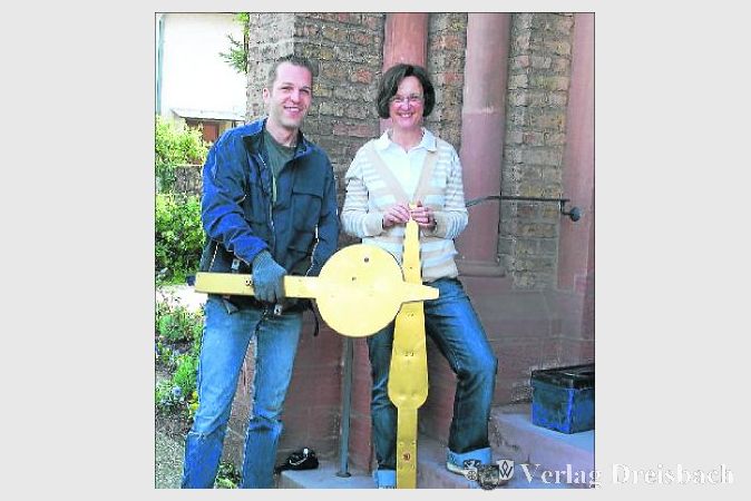 Gemeindereferentin Kornelia Schattner machte sich ein Bild von den verrosteten Turmuhrenzeiger der Weilbacher Kirche und staunte über das Gewicht der goldfarbenen Zeitmesser. Turmuhrenbauer Michael Schneider sorgt für die Überholung der maroden Zeiger.  	(Foto: Dörhöfer)