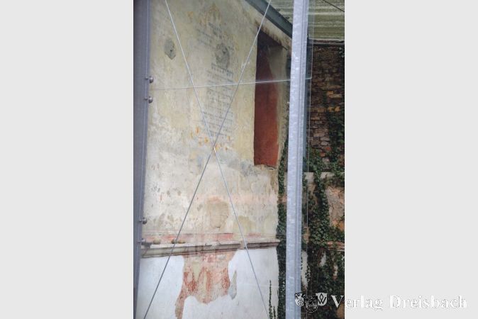 Eine einzige Wand der 1718 errichteten Synagoge ist nach der Zerst&ouml;rung 1938 erhalten geblieben. Sie ist mit einem Blick durch das Mauerfenster des Anwesens in der Synagogengasse zu sehen.

&nbsp;