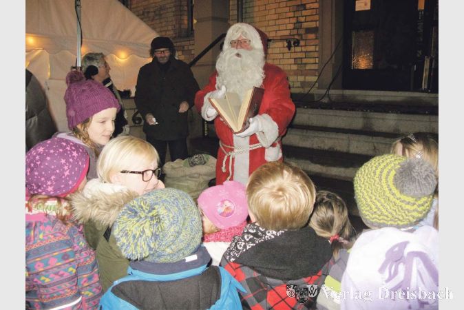 Der Nikolaus ist da! An der Rathaustreppe gab es auf dem Bischofsheimer Weihnachtsmarkt am Samstagabend eine Geschichtenstunde, aber auch kleine Gaben f&uuml;r die Kinder.
(Fotos: Engert)