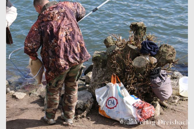 In der Plastikt&uuml;te neben diesem Angler stapeln sich schon die gro&szlig;en Fische, die in Eddersheim an Land gezogen wurden.