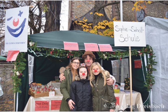 Die Sch&uuml;lervertretung der Sophie-Scholl-Schule hatte in diesem Jahr erstmalig einen Stand auf dem Weihnachtsmarkt organisiert und verkaufte Pl&auml;tzchen, deren Erl&ouml;s f&uuml;r die Clown-Doktoren bestimmt war. Clown &bdquo;Furioso&ldquo; (hinten Mitte) freute sich &uuml;ber so viel Engagement.