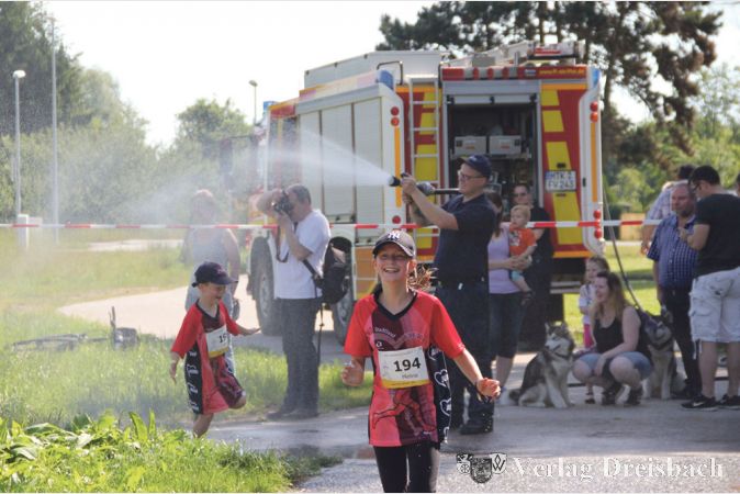 Kurz nach dem Ortseingang Okriftel sorgte die Freiwillige Feuerwehr des Ortsteils f&uuml;r eine Erfrischung der L&auml;ufer &ndash; bei Temperaturen nahe der 30 Grad waren nicht nur die L&auml;ufer des &bdquo;Kids-Run&ldquo; davon begeistert.
