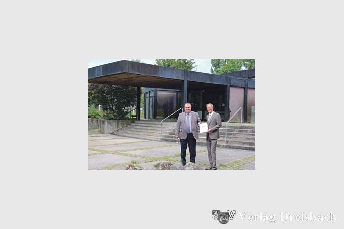 Den Gro&szlig;teil der KIP-Mittel, die Staatsminister Axel Wintermeyer (rechts) an die Stadt Hattersheim &uuml;berbrachte, wird die energetische Sanierung der im Moment ungenutzten Stadthalle verschlingen. B&uuml;rgermeister Klaus Schindling (links) freut sich dar&uuml;ber, dass es damit nun bald losgehen wird.
(Foto: A. Kreusch)