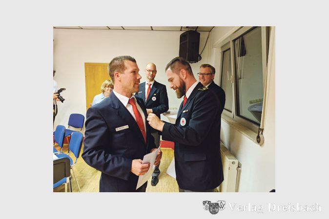 Stolz l&auml;sst sich der stellvertretende Bereitschaftsleiter Kai Mertsch die Nadel zu seinem 30-j&auml;hrigen Mitgliedschaftsjubil&auml;um anheften.