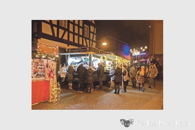 Mit Einbruch der Dunkelheit erschienen auf dem Weihnachtsmarkt noch einmal viele Besucher, die sich mit Freunden zu einer Tasse Gl&uuml;hwein trafen oder an den Essensbuden vom vielf&auml;ltigen kulinarischen Angebot kosteten.
