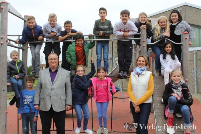 Nach der Kinderparlamentssitzung stellten sich Parlamentspräsidentin Myriam Jung und Bürgermeister Klaus Schindling mit den Kindern auf dem Pausenhof zum gemeinsamen Foto auf.