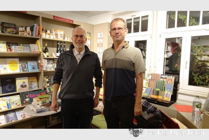 Thomas Schröder (rechts) freute sich, Jürgen Haber in der Flörsheimer Buchhandlung begrüßen zu dürfen. Zwischen kurzen Sequenzen aus aktuellen Kriminalromanen spielte er mit seinem Akkordeon „Emma“ passende, tanzbare Lieder.