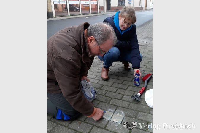 Michael Guske (Verein Stolpersteine Flörsheim) und GSG-Schülerin Gina Marie Velten beim Reinigen der Stolpersteine für Jakob und Martin Altmaier in der Hochheimer Straße.