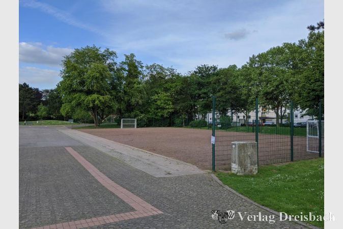Das Hinweisblatt im DIN-A4-Format ist gut gemeint, geht jedoch nur allzu leicht unter. Das Schreiben am Zaunrand seitlich des Bolzplatzes im Freizeitpark will Eltern darauf hinweisen, dass 1,5 Meter Sicherheitsabstand zwischen den Kindern einzuhalten sind und der Spielplatz gemieden werden soll, wenn zu viel Betrieb herrscht und der Abstand nicht eingehalten werden kann.