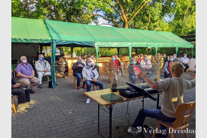 Chorleiter Sebastian W. Wagner am E-Piano, geschützt durch eine zusätzliche Kunststoffscheibe. Er selbst, wie auch alle Sänger, trugen während der gesamten Chorprobe Schutzmasken - auch während des Singens.