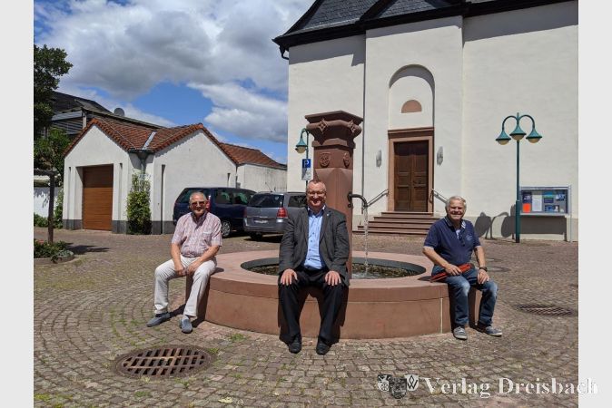 Bernd Caspari, Bürgermeister Klaus Schindlung und Werner Wagner (v. l.) am frisch restaurierten Brunnen.