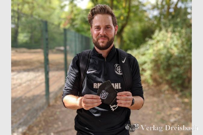 Christopher Reuter, zweiter Vorsitzender des FC Eddersheim, mit einem schwarzen Exemplar der FCE-Maske.