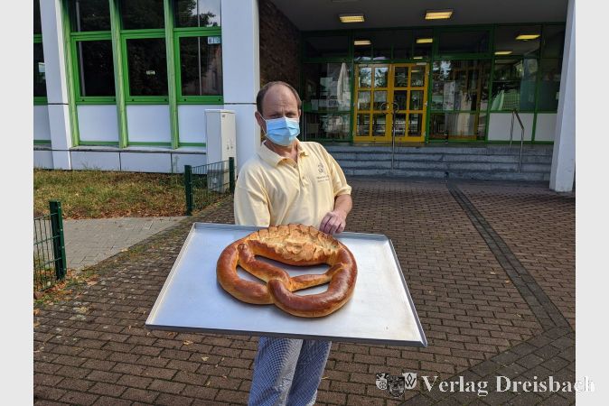Konditormeister Markus Kilb mit einer der fünf riesigen Brezeln, die jede neue erste Klasse an der Lindenschule am Donnerstag erhielt.
