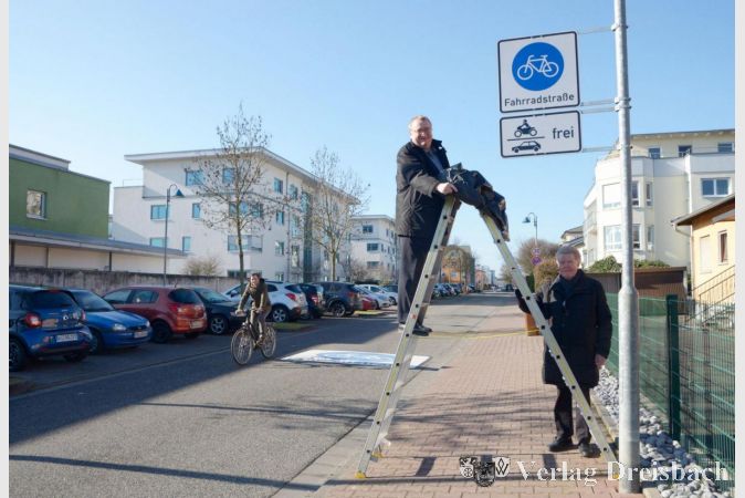 Bürgermeister Klaus Schindling und Stadtverordnetenvorsteher Günter Tannenberg am Schild, das die Weingartenstraße als Fahrradstraße ausweist.