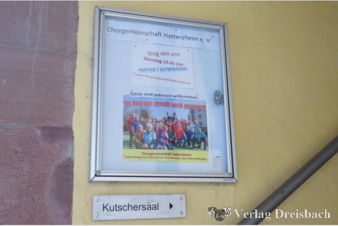 Das Schild mit der Einladung zu den Chorproben hängt noch an alter Stelle am Alten Posthof, allerdings wird man dort niemanden antreffen: Chorproben sind erst wieder bei stabilen und niedrigen Corona- Inzidenzwerten möglich.