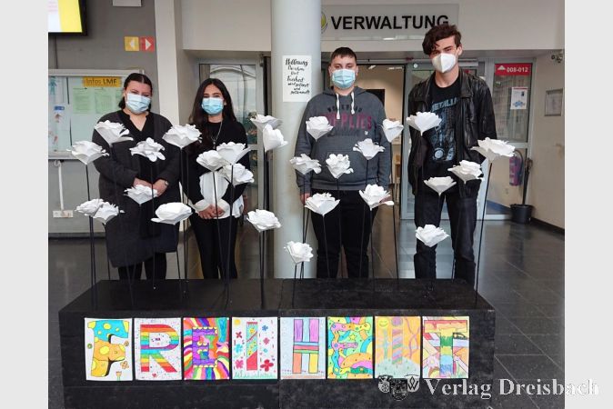 Stellvertretend für ihre beiden Klassen präsentieren Rania und Aylin (9HB) sowie Janosh und Marvin (9HA) 28 weiße Rosen. Die Skulptur "Freiheit" erinnert an den Widerstand der "Weißen Rose".