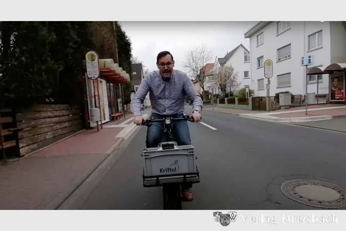 Bürgermeister Christian Seitz unterwegs mit dem Freibierfass im Fahrradkorb.