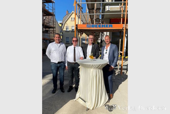 Der Erste Beigeordnete Franz Jirasek (2. von rechts) beim Richtfest mit den Geschäftsführern der Projektgesellschaft Horn Martin Kohlhepp (links), Günter Horn (2. von links) und Patrick März im Hof des neuen Wohnkomplexes am Bahnhof.