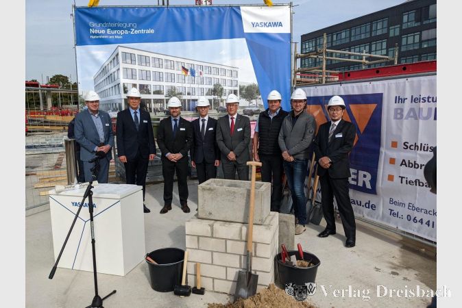 Die feierliche Grundsteinlegung mit Repräsentanten von Yaskawa und den verantwortlichen Akteuren, darunter Alexander Schwarz, Leiter der Stabsstelle Wirtschaftsförderung (links), Bruno Schnekenburger, CEO der Yaskawa Europe GmbH (2.v.l.), Martin Bender, Geschäftsführer des Bauunternehmens Weimer GmbH (3.v.r.) und Felix Feldmann, Geschäftsführer der Feldmann Architekten GmbH (2.v.r.).