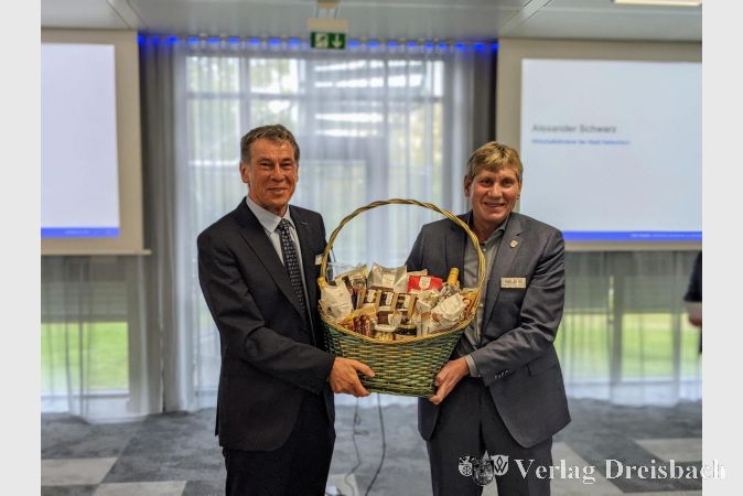 Alexander Schwarz (rechts) von der Hattersheimer Wirtschaftsförderung überreichte Bruno Schnekenburger, dem CEO der Yaskawa Europe GmbH, einen Präsentkorb mit Fair-Trade-Produkten.