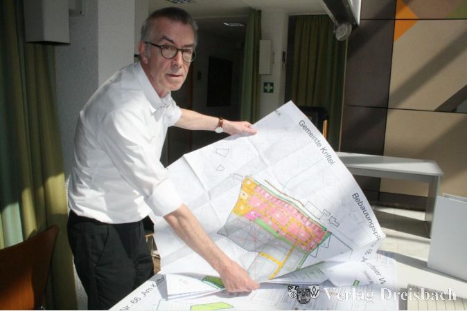 Der Erste Beigeordnete Franz Jirasek betrachtet den Bebauungsplan "Am Krifteler Wäldchen".