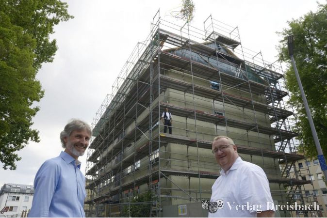 Links Hawobau-Geschäftsführer Holger Kazzer, rechts Bürgermeister Klaus Schindlung. Im Hintergrund auf dem Gerüst Zimmermann Andre Bast.