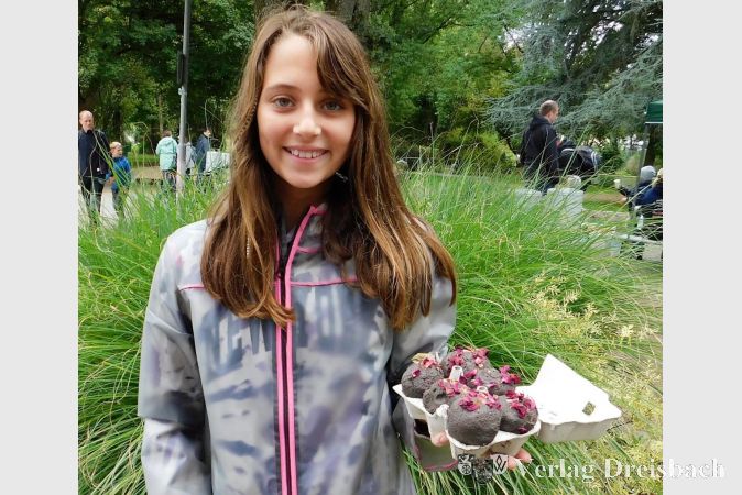 Die 10jährige Jasmin präsentiert stolz die selbstgemachten Saatbomben, die im Aussehen ein wenig an Schokoladenmuffins erinnern.