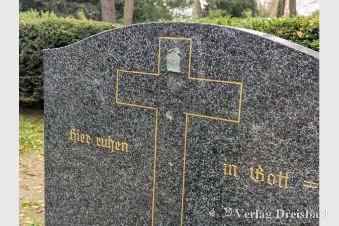 Der Schaden am Grabstein ist gut zu erkennen: Inmitten des Kreuzes sieht man die Stelle, an der das gestohlene Jesuskreuz ursprünglich verankert war.