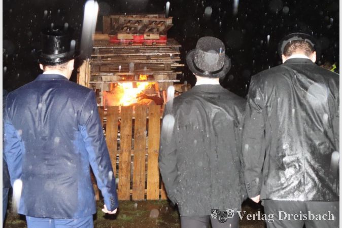Sie brennt: Die durchnässten Kerbeborsch schauen im strömenden Regen dem sich entfachenden Feuer zu, Kerbepuppe Annalena verbrennt.