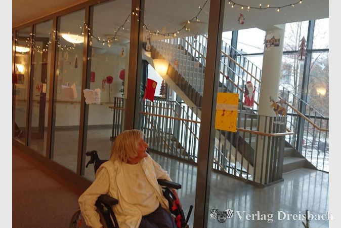 Eine Bewohnerin liest eine nach der anderen gebastelten Weihnachtskarte der Weingartenschüler.