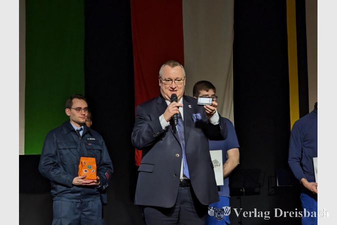 Bürgermeister Klaus Schindling präsentierte ein zusätzliches Präsent zum in der Einsatzabteilung obligatorischen Pager: Eine passende Tasche mit Schriftzug "Hattersheim am Main".