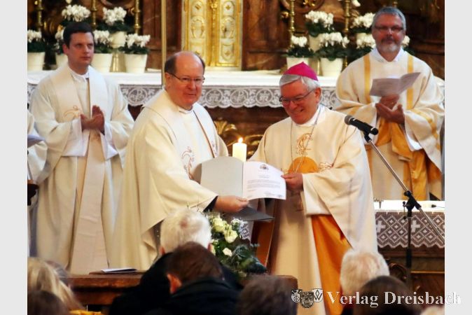 Der Moment: Weihbischof Thomas Löhr überreicht Pfarrer Friedhelm Meudt beim Gründungsgottesdienstes der Pfarrei St. Teresa am Main in der Hochheimer Kirche St. Peter und Paul die Ernennungsurkunden des Bischofs.