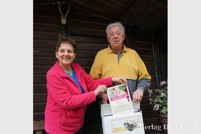 Bernhard Daubitz (links) und seine Lebensgefährtin Karin Oberbach mit dem sprechenden Briefkatsen und der Spendenurkunde von Bärenherz.