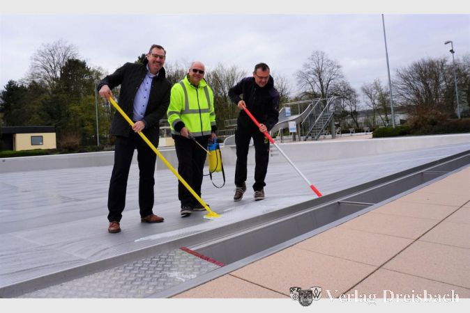 Von links nach rechts: Bürgermeister Christian Seitz und die Schwimmmeister Ralf Stössel und Alexander Wölfinger bei der Beckenreinigung.