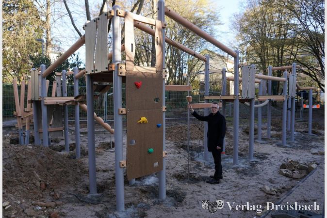 Der Erste Beigeordnete Franz Jirasek vor der neuen Spielkombination auf dem Spielplatz am Berliner Platz.