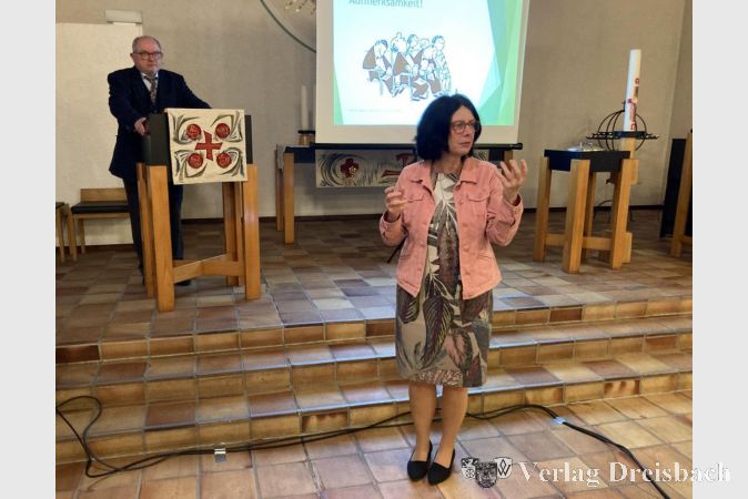 Austausch nach dem Vortrag. Im Vordergrund Pfarrerin Carmen Schneider, am Pult Prof. Wriedt.