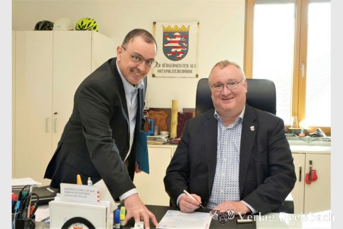 Klimaschutzmanager Andreas Flettner (links) und Bürgermeister Klaus Schindling bei der Unterzeichnung der Charta „Hessen aktiv: Die Klima-Kommunen“.