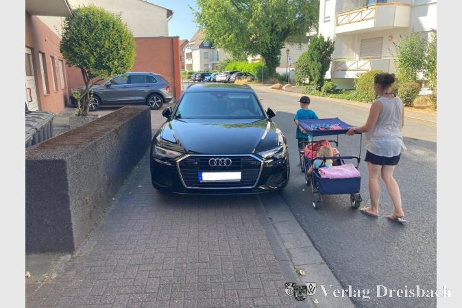 Bürgersteig zugeparkt, Fußgänger müssen auf die Fahrbahn ausweichen.