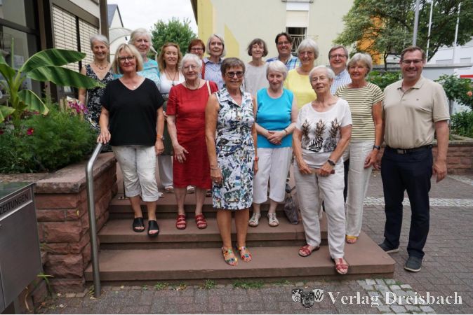 Die neue Leiterin Eva-Maria Momma (2. v. links) mit ihrer Vorgängerin Renate-Ursel Hadiprono (neben ihr im roten Kleid), Fachbereichsleiter Pasquale Fiore (5. v. rechts, hinten), Dr. Frank Fichert (3. v. rechts) und Bürgermeister Christian Seitz (rechts) sowie den Damen des Bücherei-Teams.