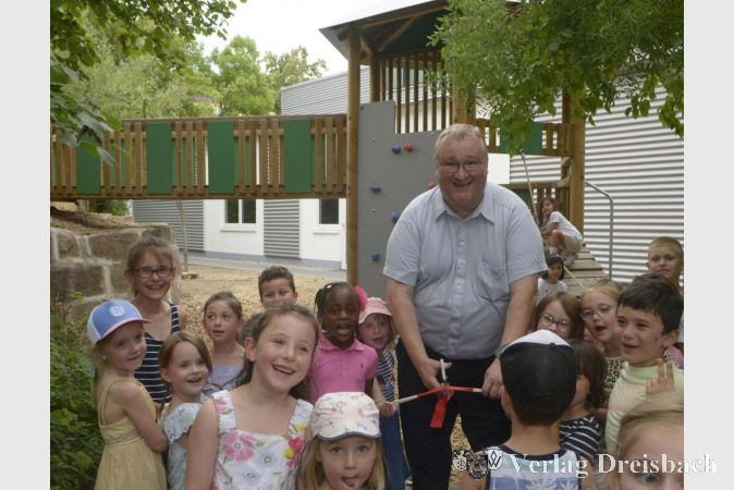 Bürgermeister Klaus Schindling bei der Einweihung des neuen Spielgeräts inmitten der Kinderschar.