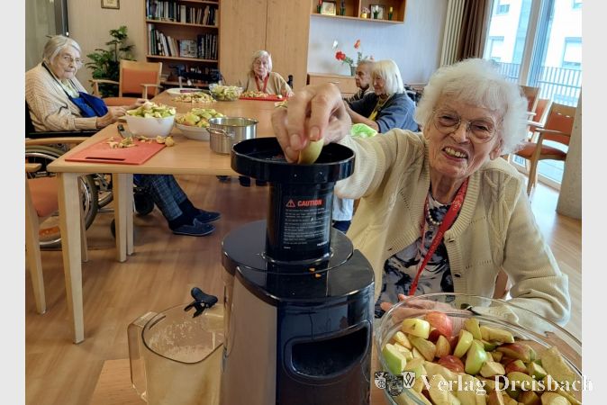 Bewohnerin Margot Seeger bei der Verabreitung der Apfelernte im Kursana Domizil.