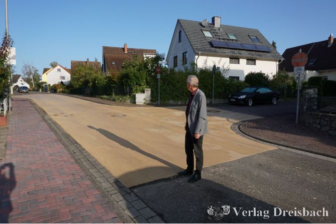 Der Erste Beigeordnete Franz Jirasek vor einer neuen farbigen Asphaltfläche an der Ecke Leicherstraße/Steinstraße.