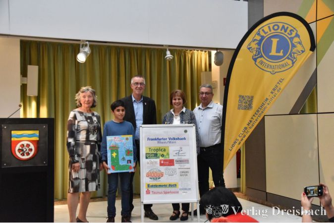 Lions-Präsidentin Marion Uhle-Fassing (2. v. rechts), der Krifteler Erste Beigeordtene Franz Jirasek (Mitte) sowie der kleine Künstler Matteo Ribaudo (2. v. links) mit seiner Familie bei der Vorstellung des neuen Lions-Adventskalenders im Krifteler Rat- und Bürgerhaus.