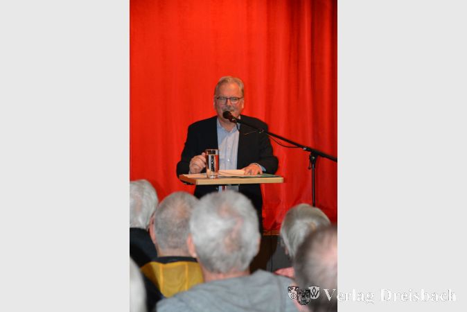 Bürgermeister Dr. Bernd Blisch beleuchtet die vielfältige Zuwanderungsgeschichte von Flörsheim im historischen Vortrag in der Kulturscheune.