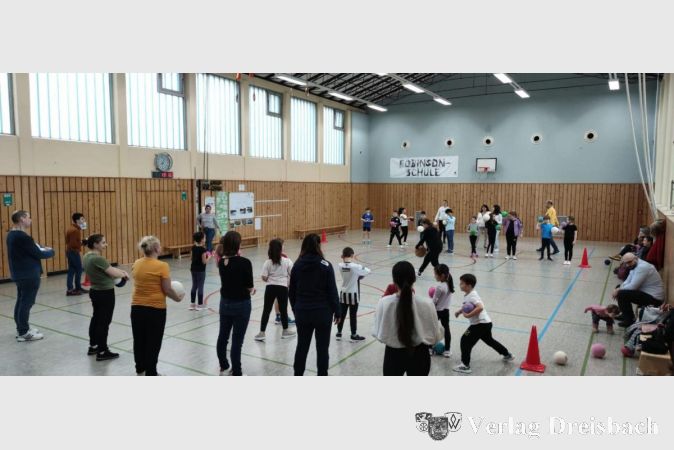 Alle Familien und Freunde während eines Ballspiels in der Sporthalle.