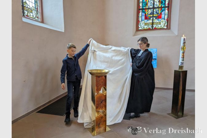 Der Täufling Luis Zauner und Pfarrerin Anne Müller enthüllten am Ostermontag im Gottesdienst das neue Taufbecken.