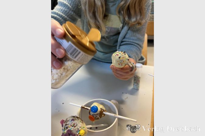 Zubereitung von süßen Cake-Pops, auch als Kuchenlollis oder kleine Kuchen am Stiel bekannt.