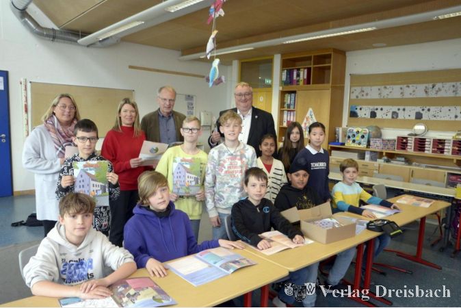V.l.n.r.: Teilhabeassistentin Michaela Rosemann, Klassenlehrerin Heike Krüger, Schulleiter Uwe Simon und Bürgermeister Klaus Schindling bei der Lernheftübergabe an die Schülerinnen und Schüler der Klasse 4a.