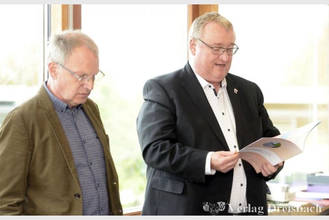 Bürgermeister Klaus Schindling (rechts) bei der Überreichung der Lernhefte an Schulleiter Uwe Simon.